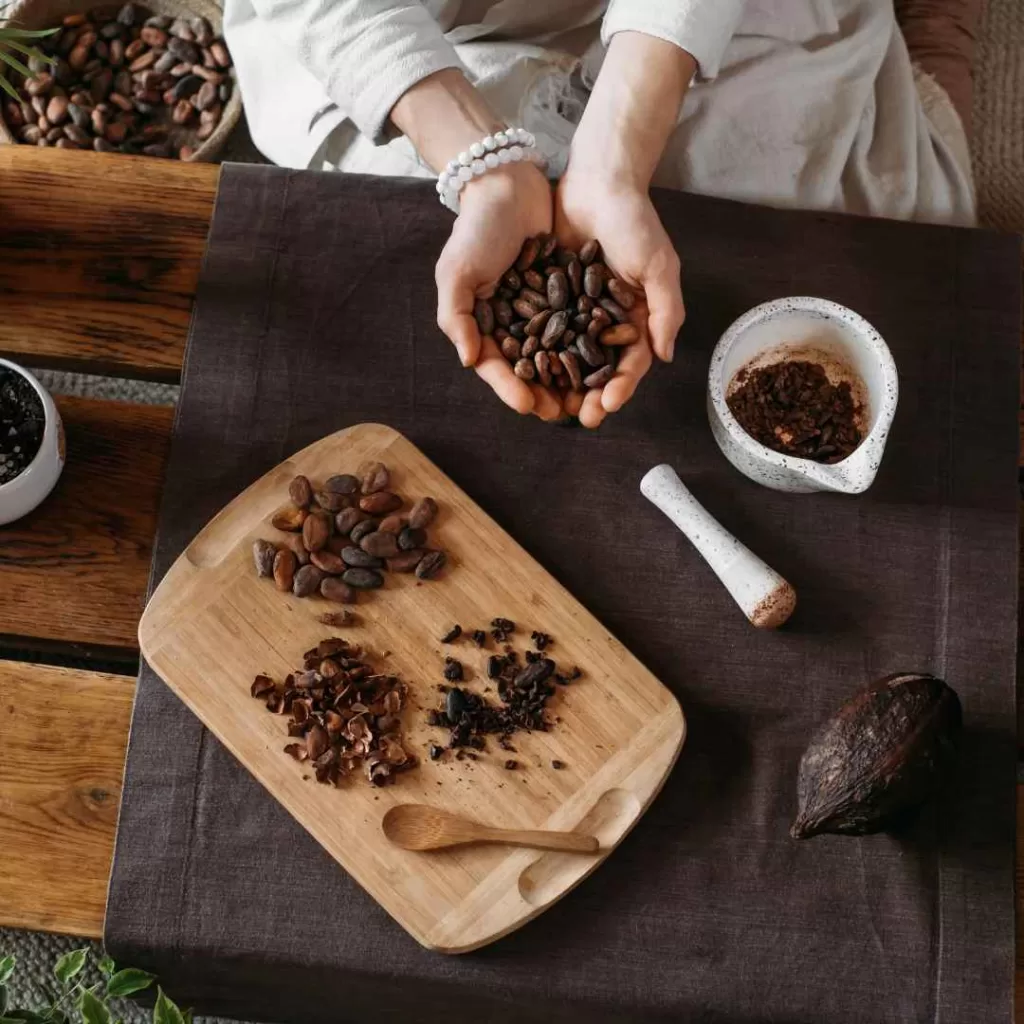 A serene outdoor setting with a steaming cup of organic ceremonial sipping cacao on a rustic wooden table, nestled among lush green foliage.
